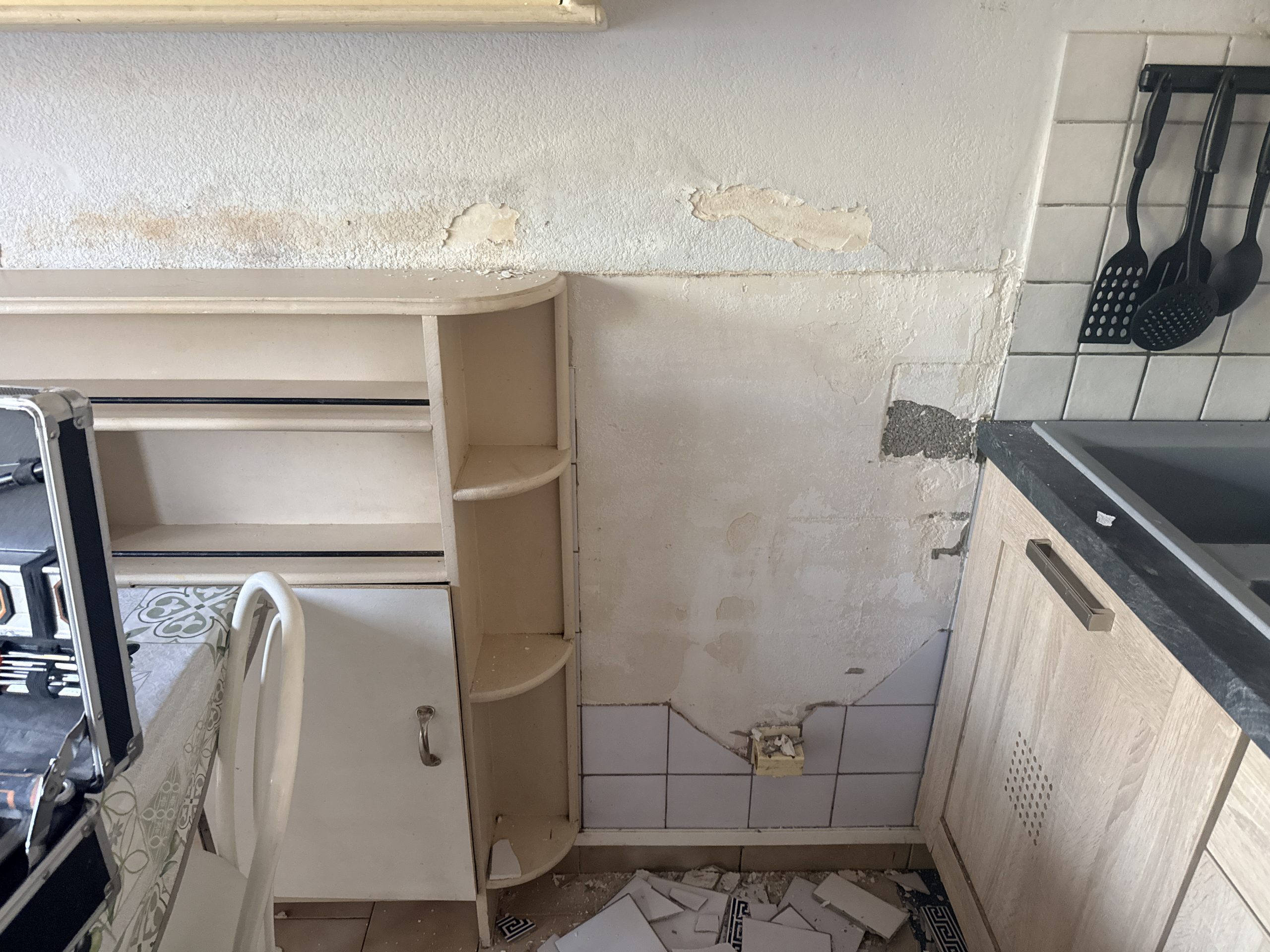 Mur dégradé par l'humidité derrière la faïence de cuisine