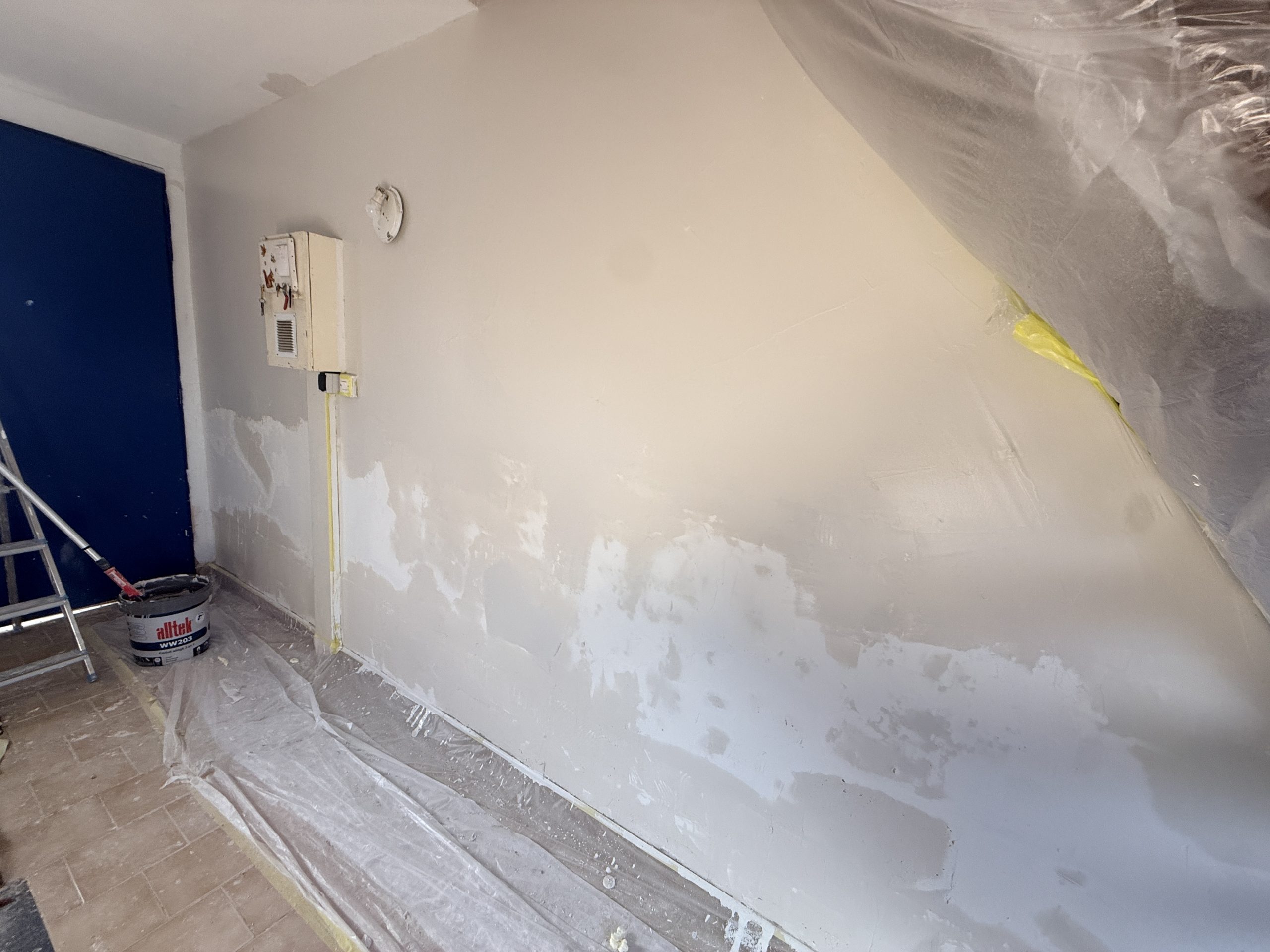 Mur ratissé à l'enduit fibré, protections en place