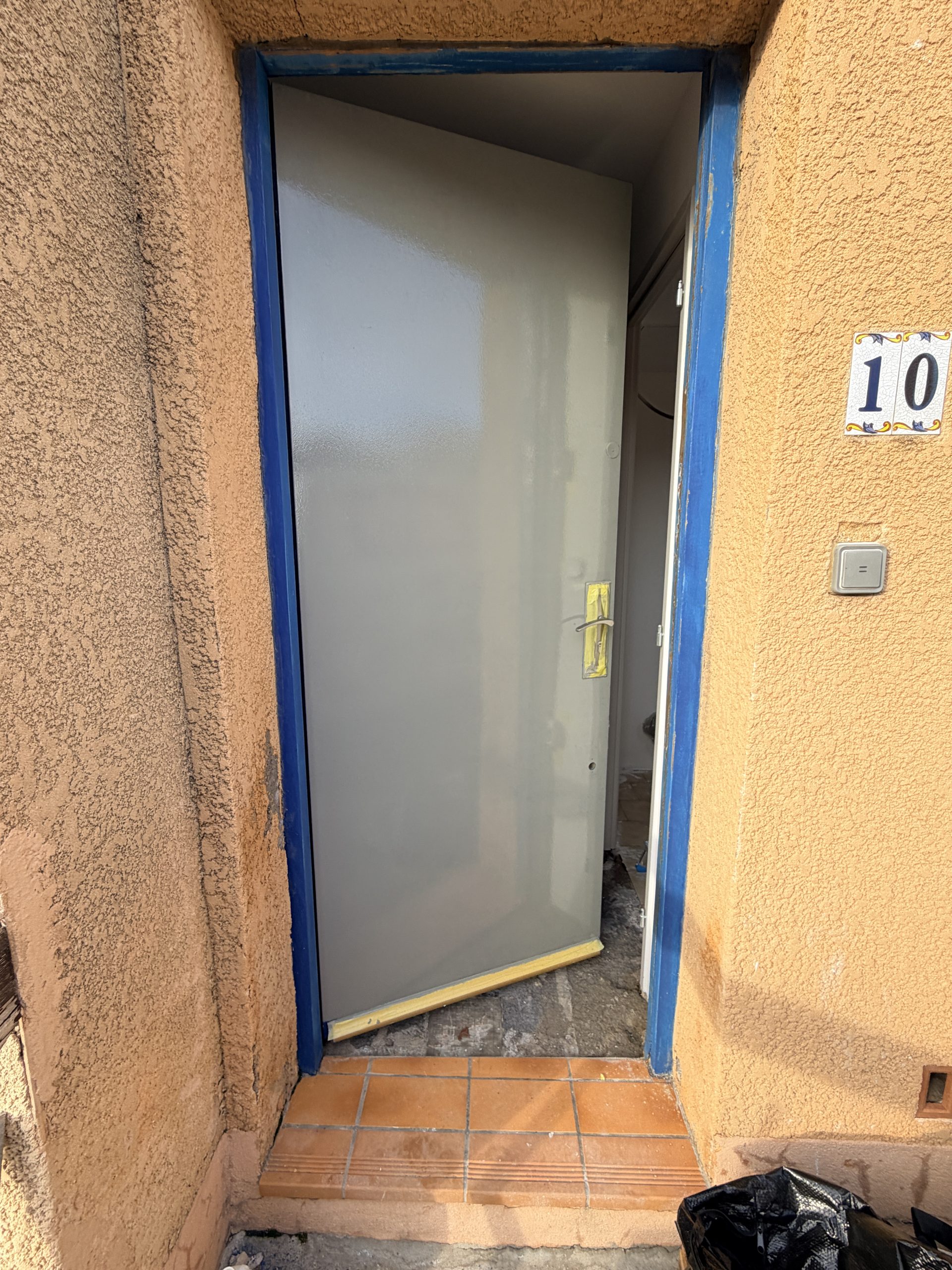 Application de la peinture antirouille grise sur la porte