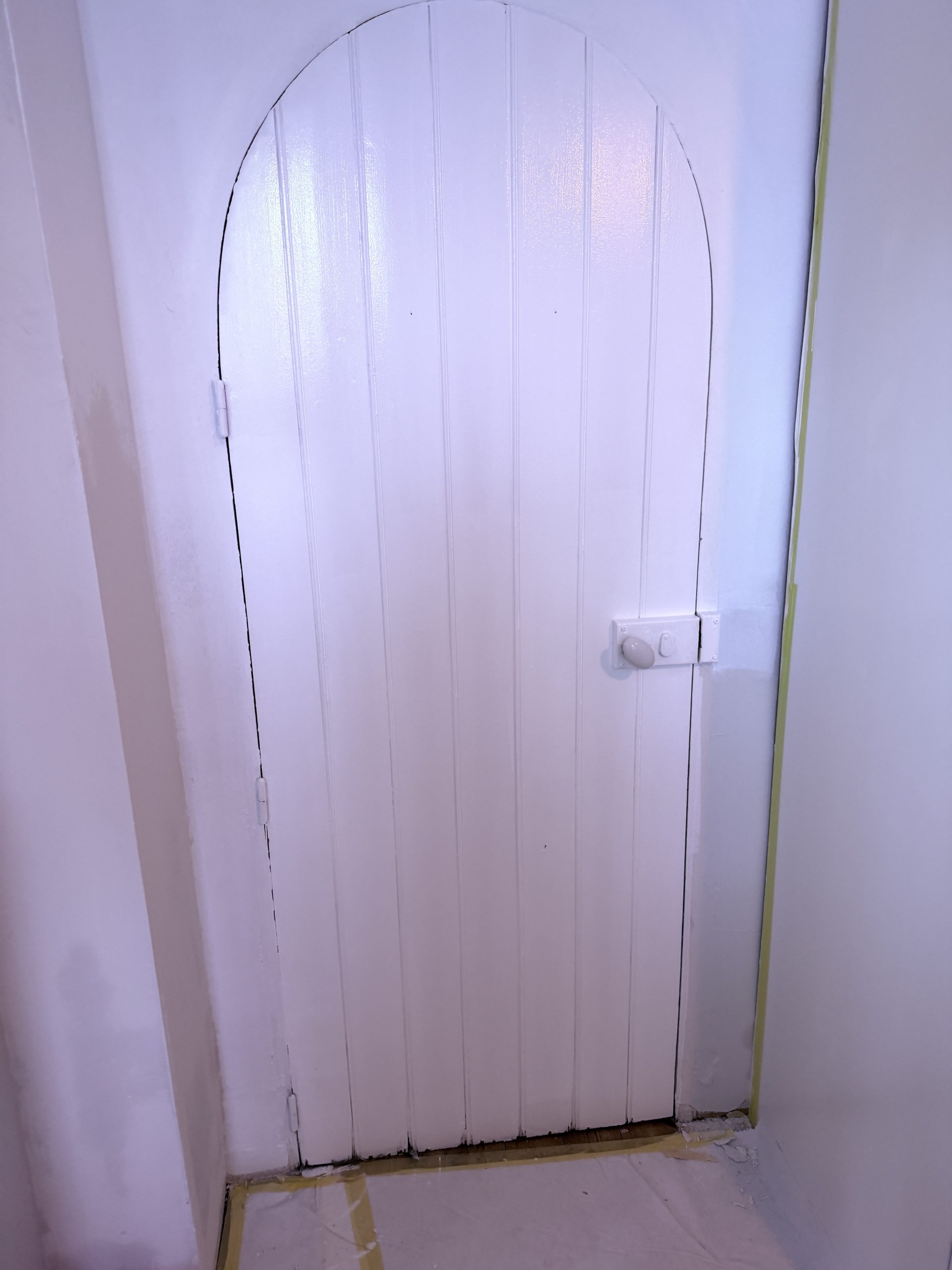 Porte cintrée en lambris terminée en blanc velours