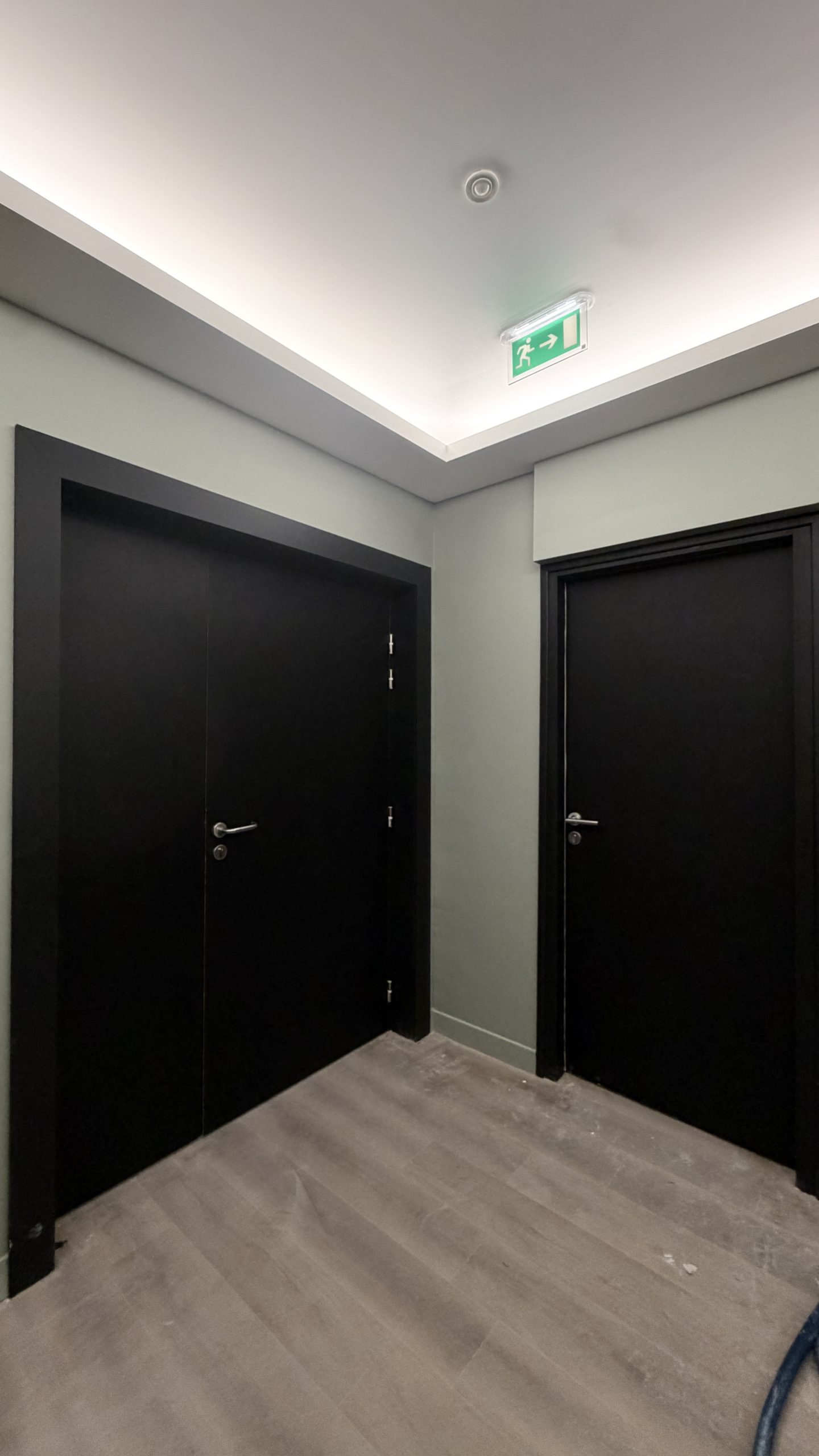 Couloir avec portes rénovées par covering, finition noir mat